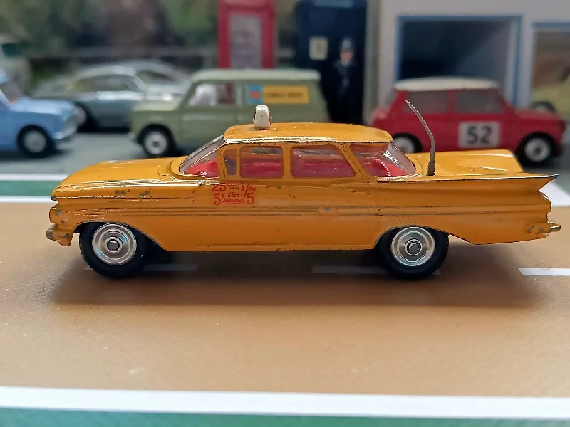 N - Scale Model Train Layout with a City - Themed Background and Animated Figures221 Chevrolet Impala Yellow Cab